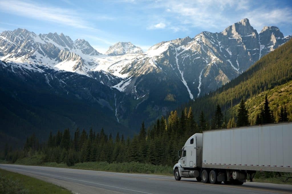 White Shipping Truck Delivering To The Mountains