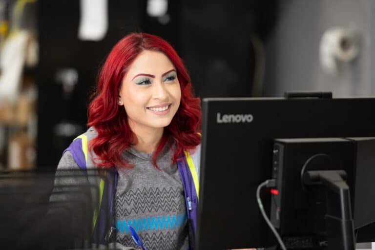 Woman With Red Hair Smiling While Working